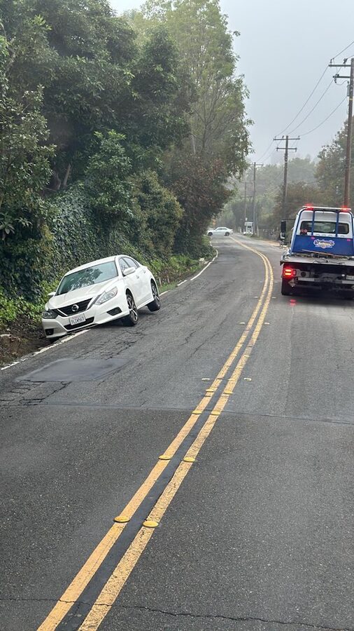 Graham's Towing assisting a stranded car on a foggy Orange County roadside