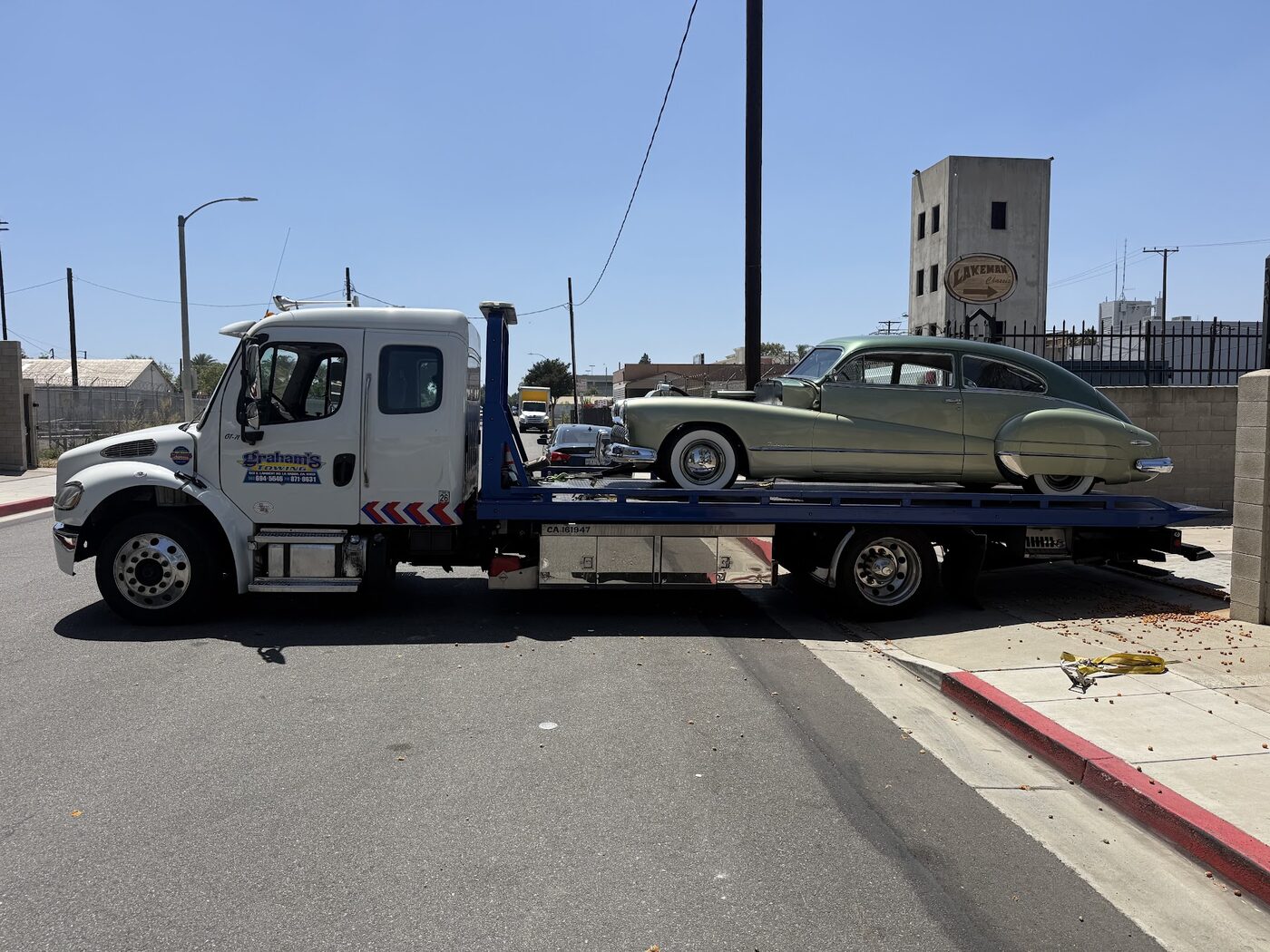 Classic green Buick transported locally on a Graham's Towing flatbed