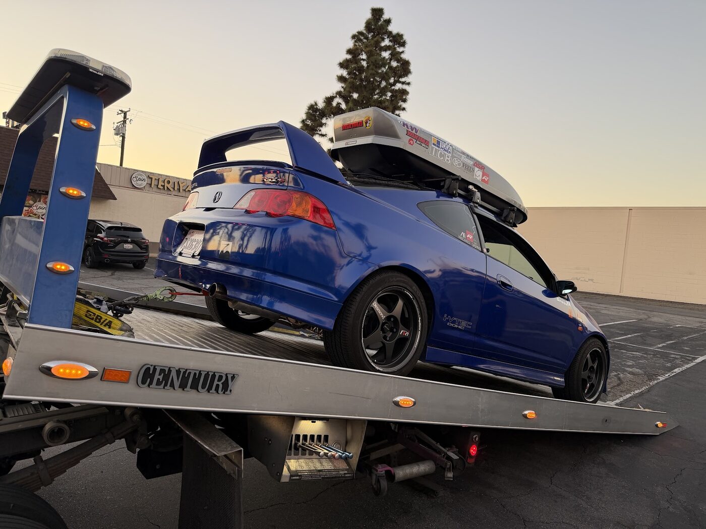A car loaded on a Graham's Towing flatbed at sunset in Orange County