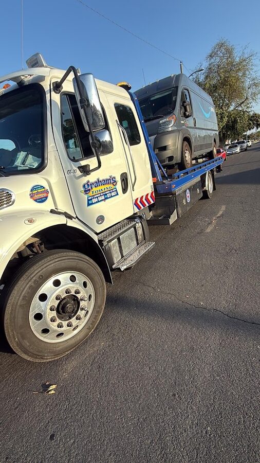 A commercial van loaded on a Graham's Towing flatbed