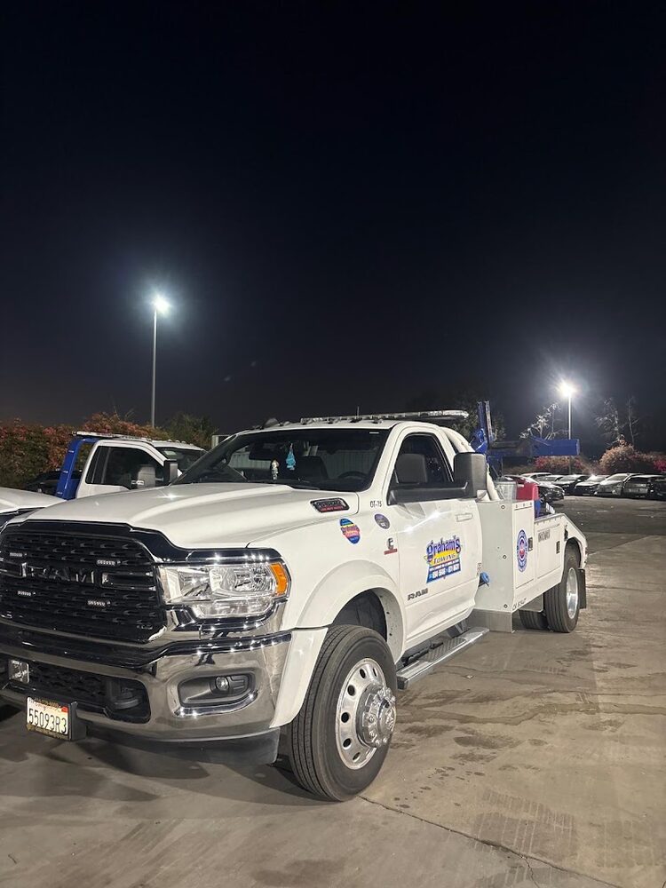 Graham's Towing RAM wheel-lift wrecker truck staged at night